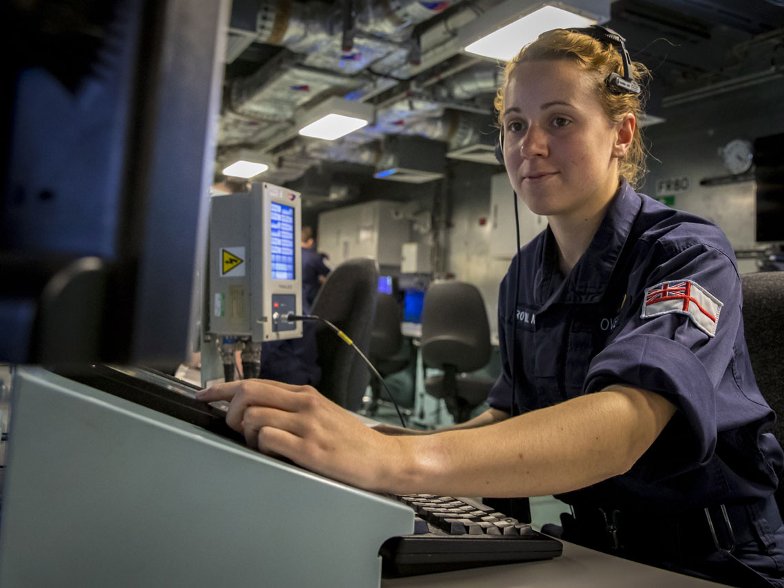 A trainee officer at a console in the operations room of HMS Queen Elizabeth