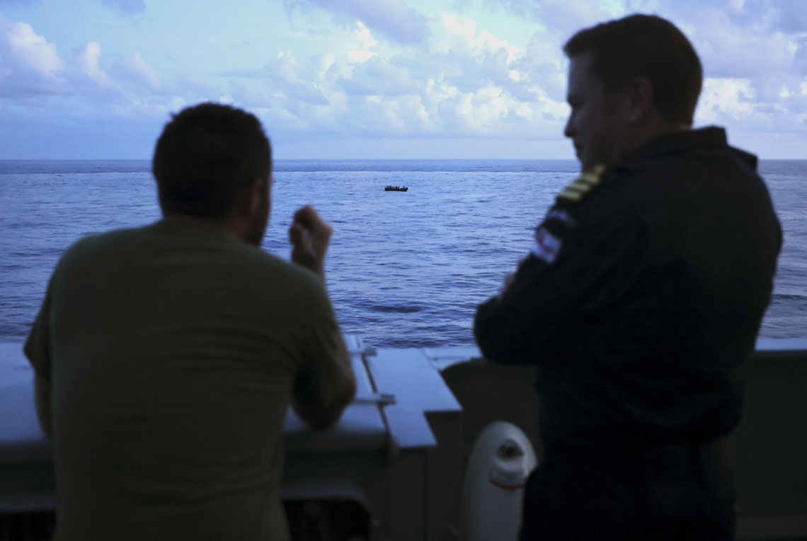Commander Chris Hollingworth RN on the right and a member of The US Coast Guard Law Enforcement Team with the target vessel in the background