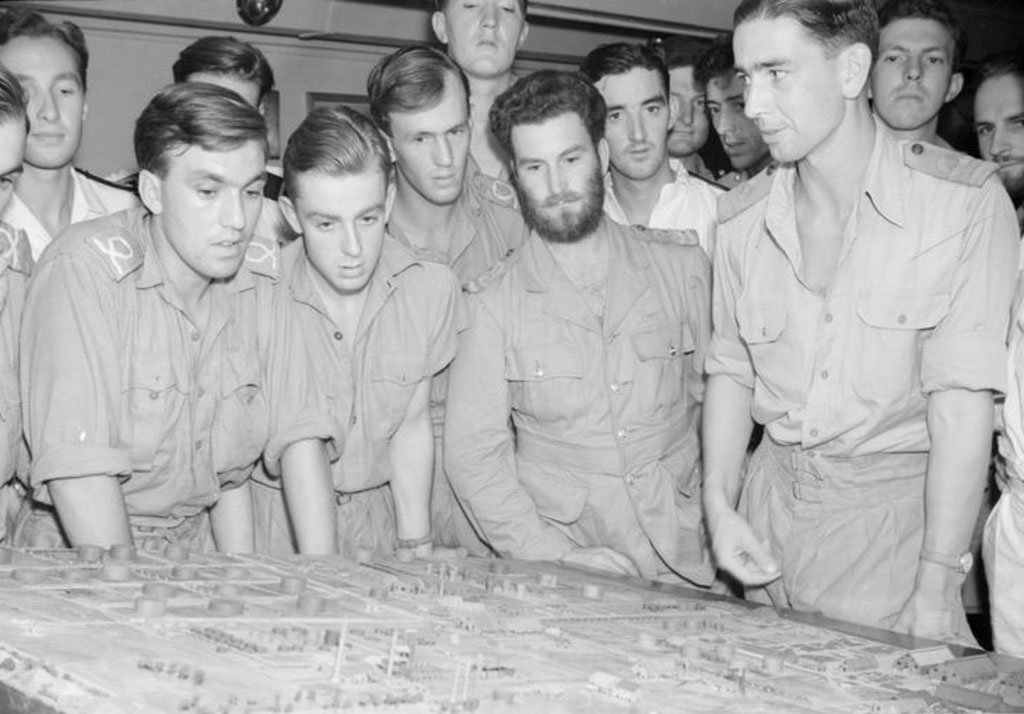 Aircrew on HMS Illustrious study a detailed model of the refineries