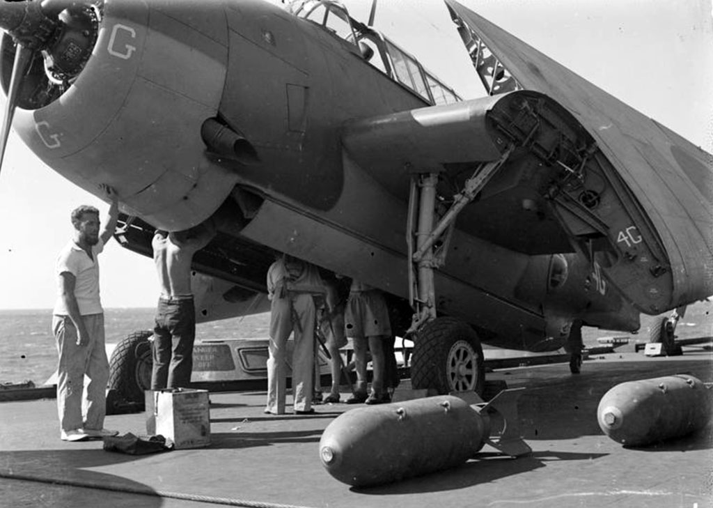 Armourers prepare an Avenger on HMS Illustrious for 'bombing up'