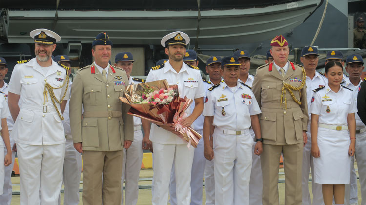 Commander Tom Lindsey receives a traditional welcome from his Cambodian hosts